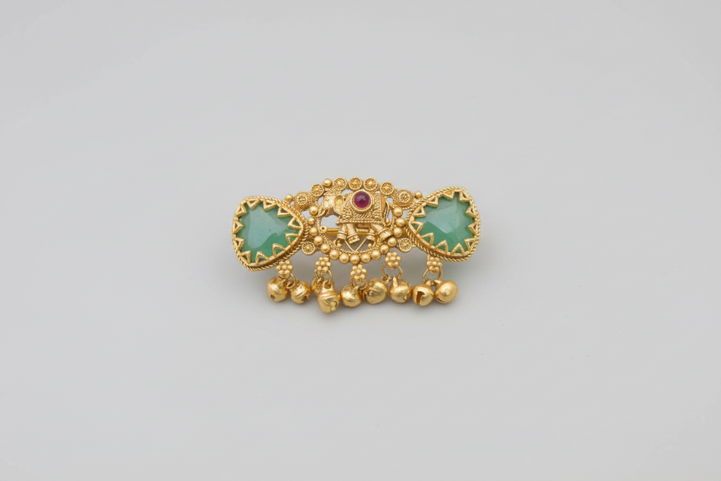 Decorative gold ring with green stones and a red gemstone on a dark background