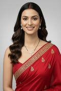 A modern silver-toned mangalsutra featuring a traditional black bead chain and a V-shaped pendant densely set with small clear crystals. The pendant features a central teardrop motif with a small crystal hanging beneath it, displayed against a blue velvet background.