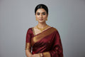 Gold necklace and earrings on a black stand against a dark background