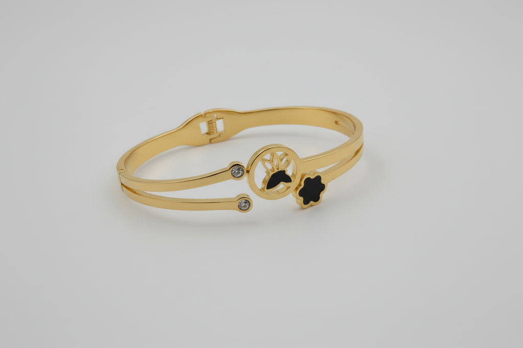 Gold bracelet with a decorative design on a textured surface