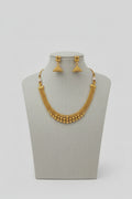 A modern gold-toned choker necklace featuring four layered strands of polished round beads that graduate in size toward the center, shown worn on a neck against an orange and white background.