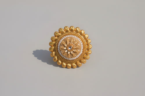 Gold decorative button on a textured green surface