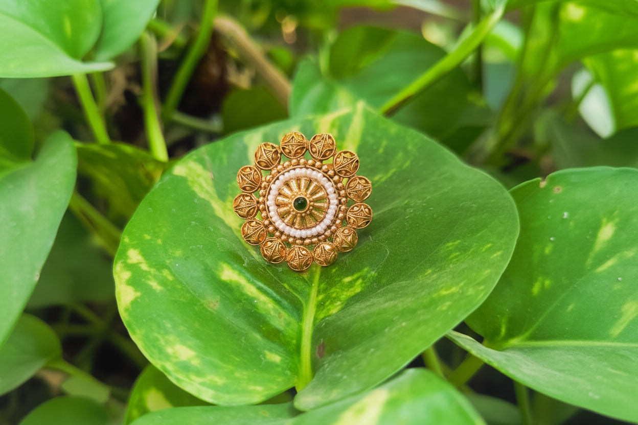 Decorative gold ring on a green leaf