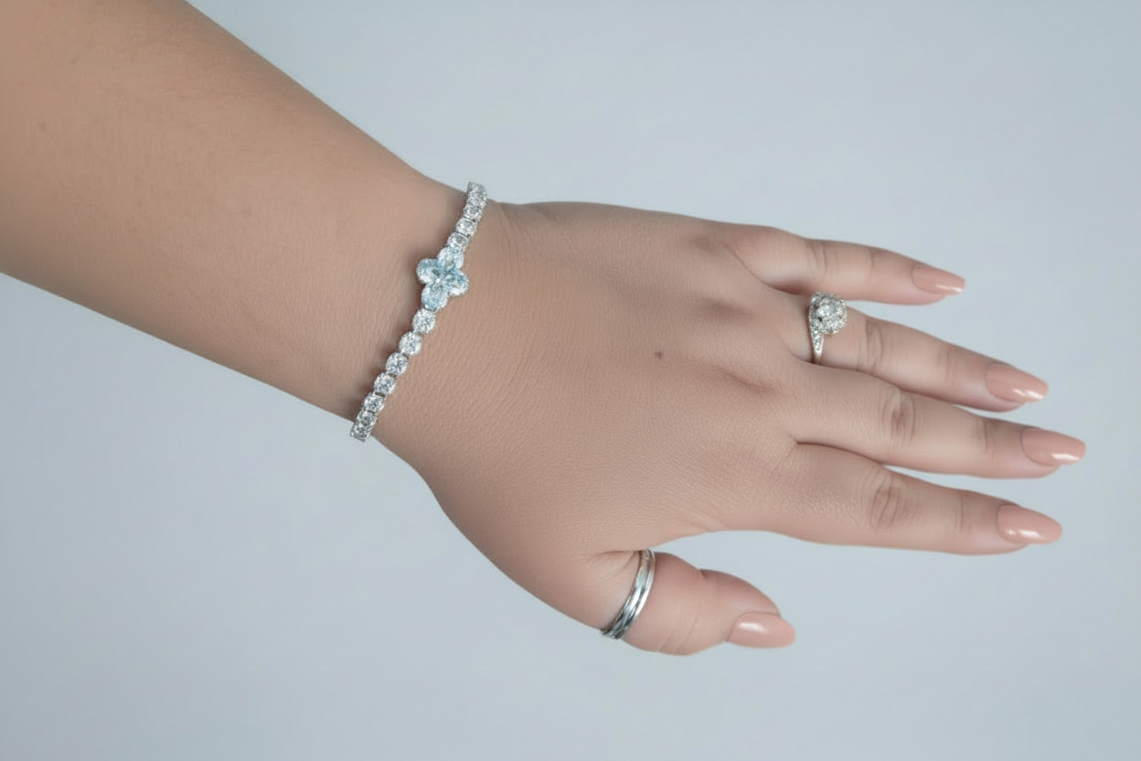 Hand wearing a bracelet and ring on a light gray background