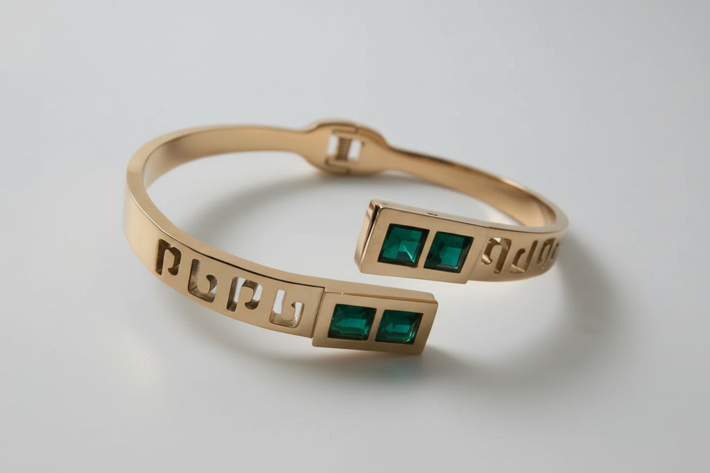 Rose gold bracelet with green stones on a textured white surface