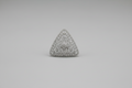 Triangular textured object held in a hand against a black background