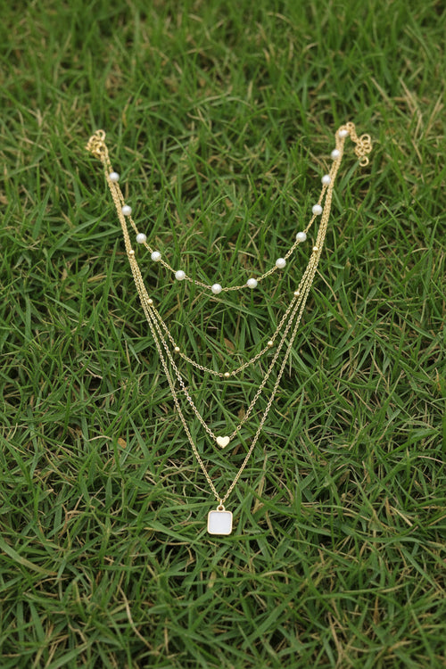 Multi-strand gold necklace for women featuring pearl beads, heart pendant, and square stone