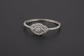A silver-toned statement bangle with a large central circular cluster of clear crystals flanked by two diamond-shaped stones, featuring a fully encrusted band on a dark textured surface