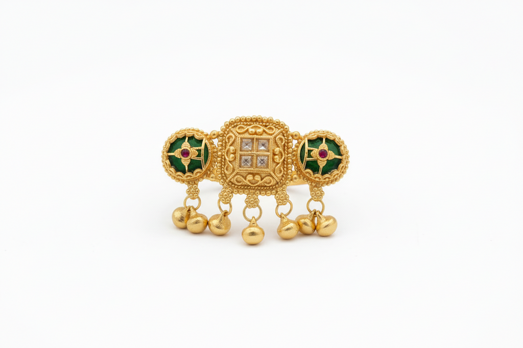 Gold ring with intricate design on a hand in front of a laptop keyboard