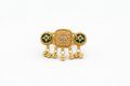 Gold ring with intricate design on a hand in front of a laptop keyboard