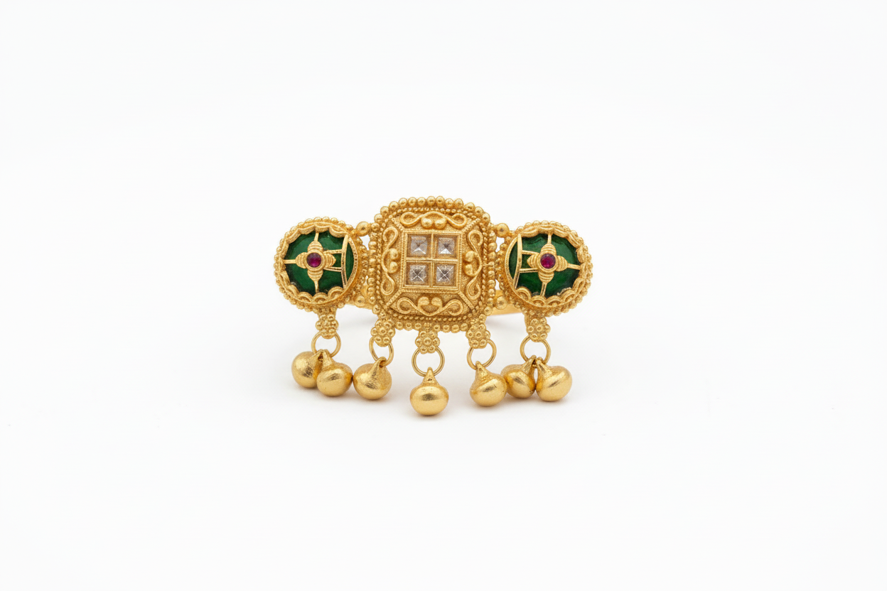 Gold ring with intricate design on a hand in front of a laptop keyboard