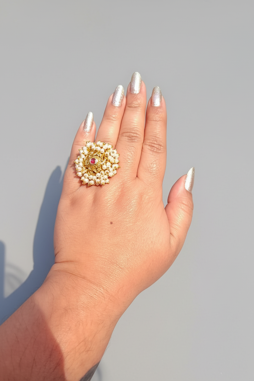Hand wearing a decorative ring with a green background