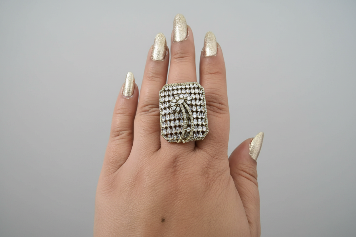 Hand wearing a large diamond ring on a green background