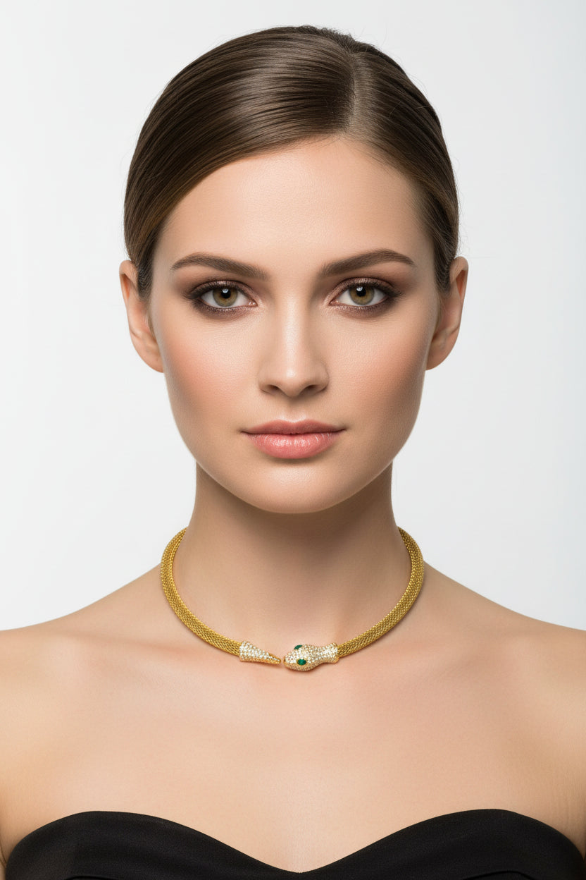 Woman wearing a gold necklace with a green gemstone on a white background